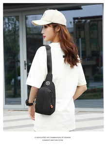 Detail of waterproof nylon chest bag with orange zipper accents and adjustable strap