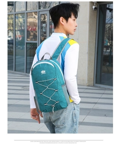 Detail view of teal foldable outdoor backpack with elastic cord system and mesh pocket