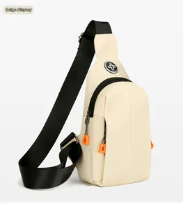 Detail view of beige crossbody bag with adjustable black strap and orange zipper accents