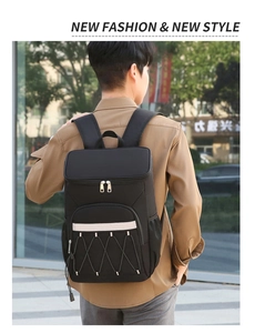Outdoor street shot of a black insulated picnic backpack with reflective straps and mesh side pockets