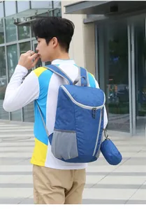 Blue foldable travel backpack on male model showing lightweight waterproof nylon material
