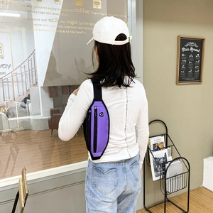 Sac banane de sport violet et noir tendance porté en sac de poitrine dans un café