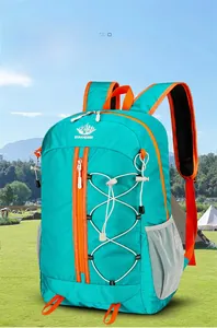 Blue foldable outdoor backpack with orange zippers shown in a scenic hiking environment