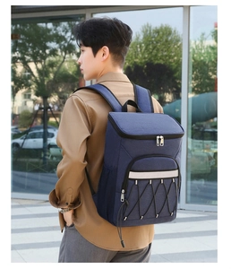Detailed view of the large navy blue insulated backpack being worn in an outdoor city setting