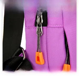 Macro detail of purple Oxford fabric bag with textured metal zipper and orange puller