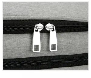 Detail of smooth double metal zippers and durable grey woven fabric on the picnic backpack