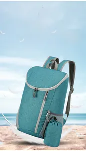 Lightweight blue folding backpack shown with feathers to highlight its portable design