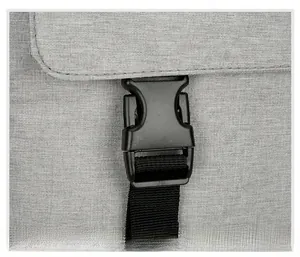 Detail of high-quality black plastic buckle and durable woven strap on gray picnic backpack
