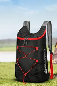 Outdoor folding skin pack with red bungee cords and gray mesh straps against a tent background