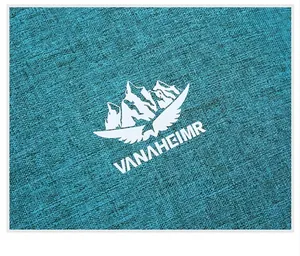 Detail of teal textured fabric with white VANAHEIMR logo print on foldable backpack