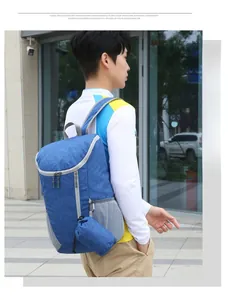 Outdoor model wearing a large blue water-resistant travel backpack with side mesh pocket