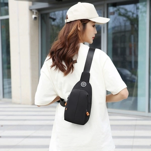Waterproof black nylon chest bag for women with orange zipper pulls and crossbody strap