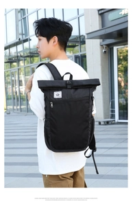 Close-up of black roll-top outdoor backpack with durable fabric and buckle closure