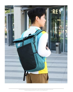 Outdoor lightweight folding backpack with roll-top buckle shown on male model in city