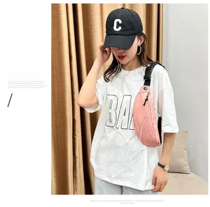 Vue détaillée du sac banane rose en nylon imperméable avec bandoulière réglable en travers