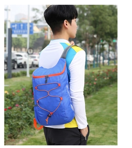 Close-up of blue foldable outdoor backpack featuring orange elastic cords and mesh straps