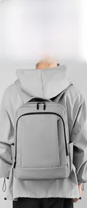 Detail view of the sleek gray waterproof commuter backpack on a model showing back comfort