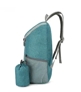 Side view of foldable teal backpack with grey mesh pocket and matching storage pouch