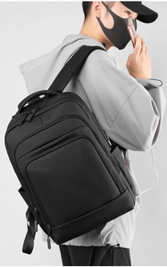 Macro detail of ergonomic padded shoulder straps and USB charging port on black backpack