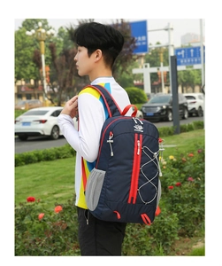 Detail of a lightweight foldable outdoor backpack with red zippers and side mesh pockets