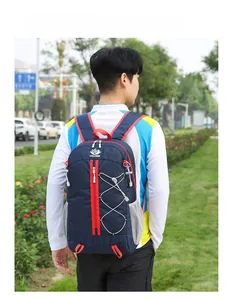 Detail of blue outdoor backpack with red zippers and elastic cord storage system