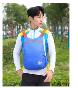 Nahaufnahme des wasserdichten blauen Rucksacks mit orangen Reißverschlüssen auf dem Model