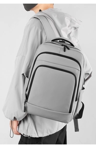 Close-up of a minimalist light gray men's business backpack with multiple zip pockets