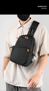 Détail du sac de poitrine en nylon noir imperméable avec tirettes de zip orange vif