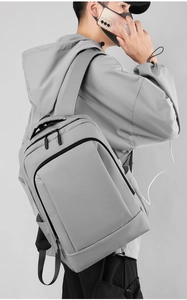 Detail showing side USB charging port on light grey waterproof business backpack
