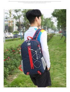 Navy blue foldable outdoor backpack with red straps and front elastic bungee storage