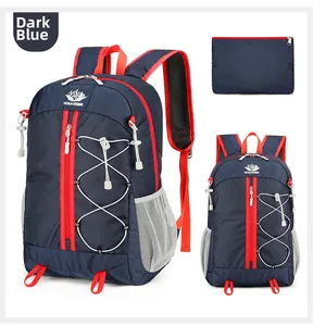 Detail view of foldable dark blue hiking backpack with red zipper accents and storage pouch