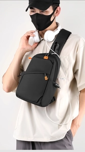 Gros plan du sac de poitrine noir avec tissu imperméable et détails de fermeture éclair orange