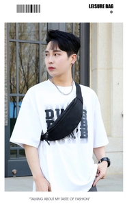 Détail d'un sac banane en nylon noir imperméable porté par un mannequin homme en ville