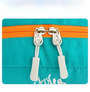 Macro shot of durable double zippers on teal ripstop fabric with orange zipper tracks