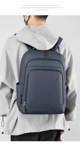 Detail of navy blue business backpack showing multiple compartments and side water bottle pocket