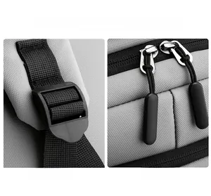 Detail of adjustable strap buckle and smooth metal dual zippers on gray laptop backpack