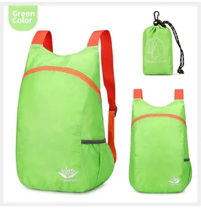 Detailansicht faltbarer grüner Nylon-Rucksack mit orangen Trägern und kompaktem Beutel