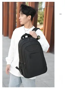 Man carrying a black large capacity commuter backpack showing its side mesh water bottle pocket