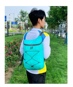 Cyan ultralight foldable backpack shown on back during outdoor travel activities