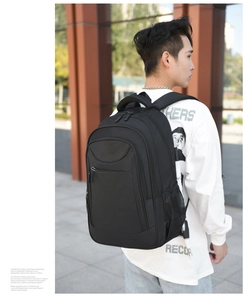 Side view of a black multi-functional backpack worn by a model in an urban outdoor setting