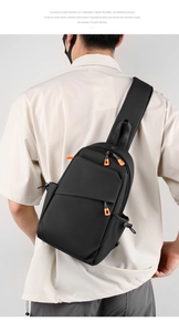 Vue détaillée du sac de poitrine noir avec des tirettes de fermeture éclair orange vif