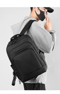 Detail of minimalist black business backpack with integrated USB port and water-resistant nylon