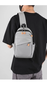 Détail du sac bandoulière gris d'extérieur avec tissu résistant à l'eau et tirette orange