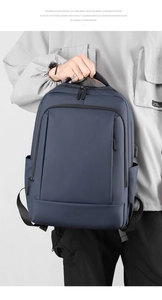 Deep blue water-resistant commuter backpack shown on a model with grey jacket detail