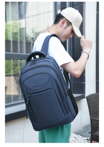 Side view of dark blue business backpack with padded straps on model outdoors