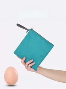 Ultralight foldable travel bag compared to an egg to show its extreme lightweight nature