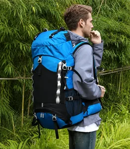 Blue 60L hiking backpack worn by hiker in lush bamboo forest, showing side gear straps