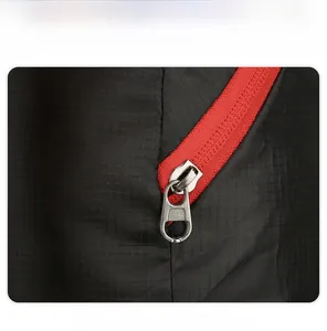 Detail eines robusten Metallreißverschlusses mit rotem Band auf dem Rucksack