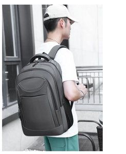 Deep gray commuting backpack with multiple zipper compartments and side mesh pocket