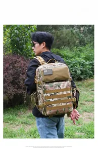 Detail view of large tactical CP camouflage backpack with American flag patch in outdoor use